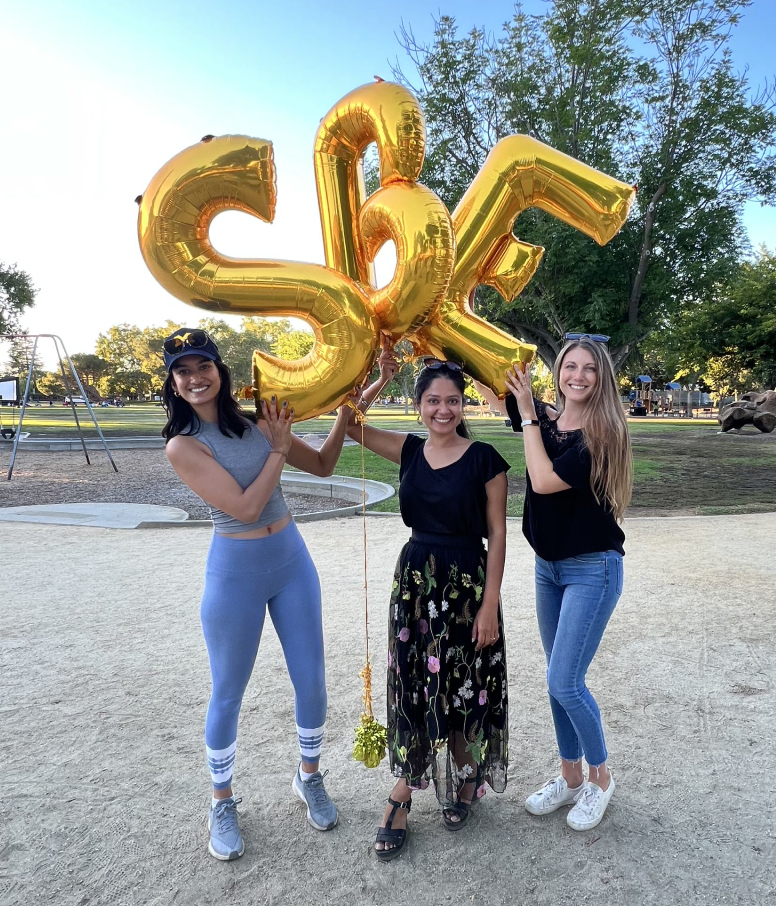 Three women and gold "SBE" balloons